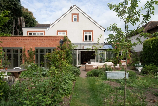 Modern house garden in Horsley, Surrey featuring landscaped lawn and contemporary architecture, location by Love Locations.