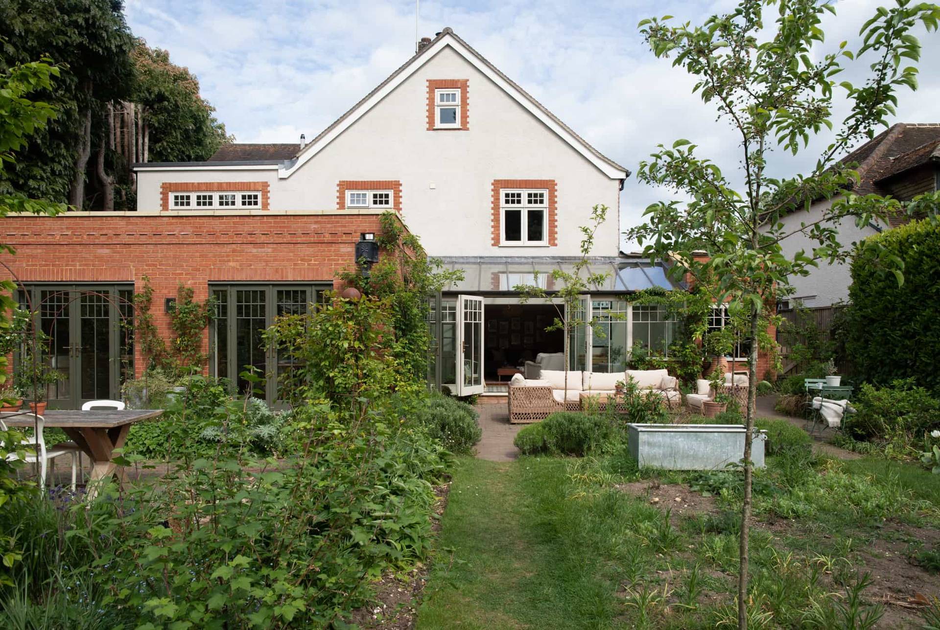 Modern house garden in Horsley, Surrey featuring landscaped lawn and contemporary architecture, location by Love Locations.
