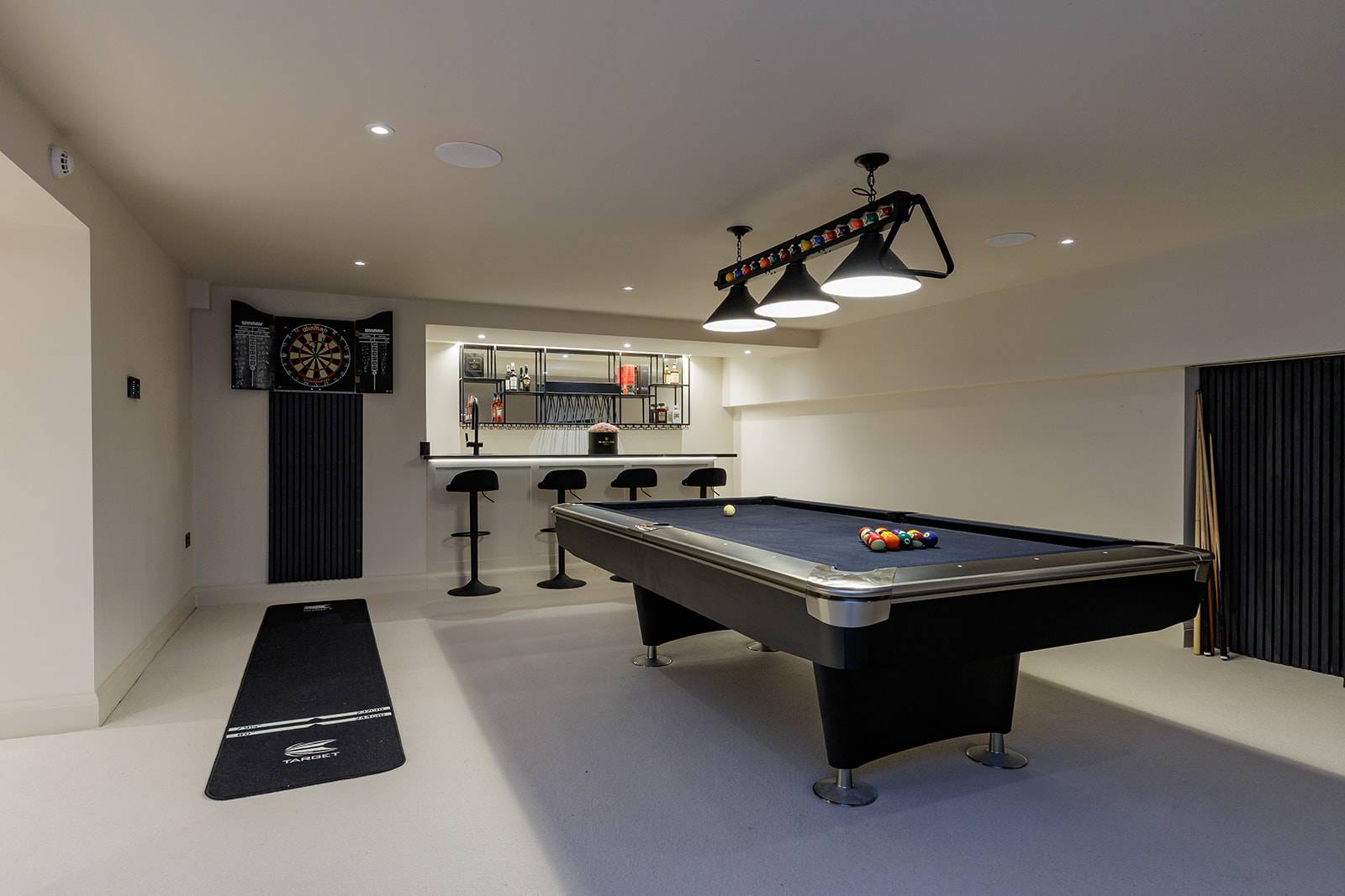 Games room layout with a pool table, dartboard setup, and bar seating alcove, Love Locations RH13.