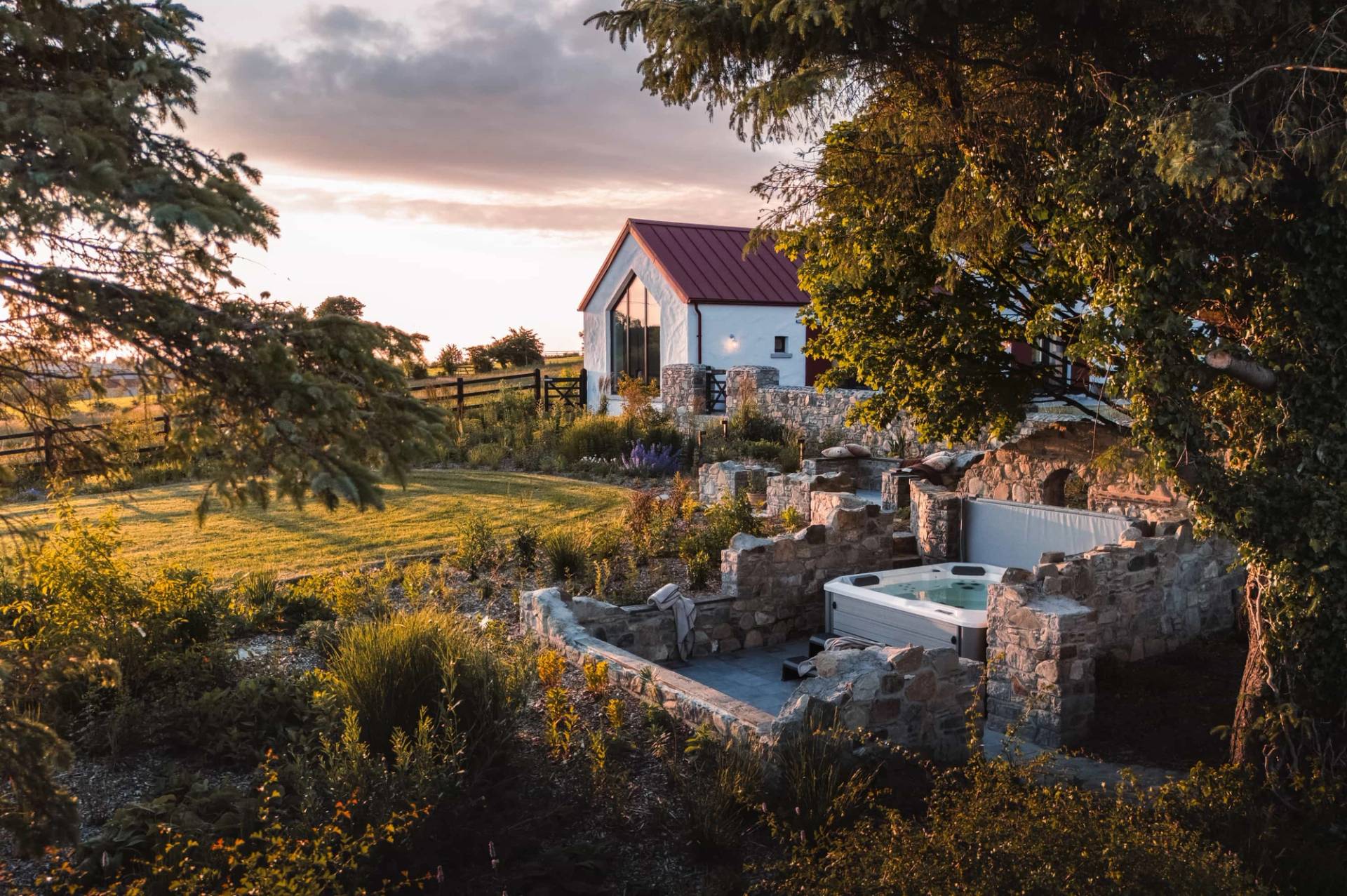 Outdoor hot tub and terrace film location in Castleblayney County Monaghan Ireland through Love Locations, set within stone walls during sunset.