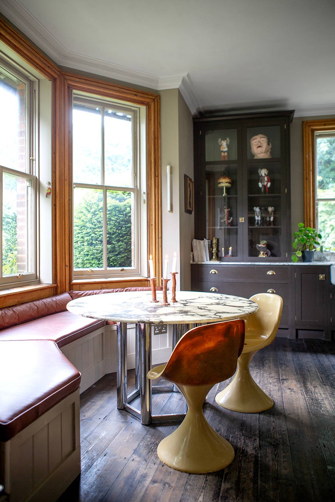 Sunlit dining nook set into a sash bay window with a round dining table and mustard chairs, Love Locations ME13.