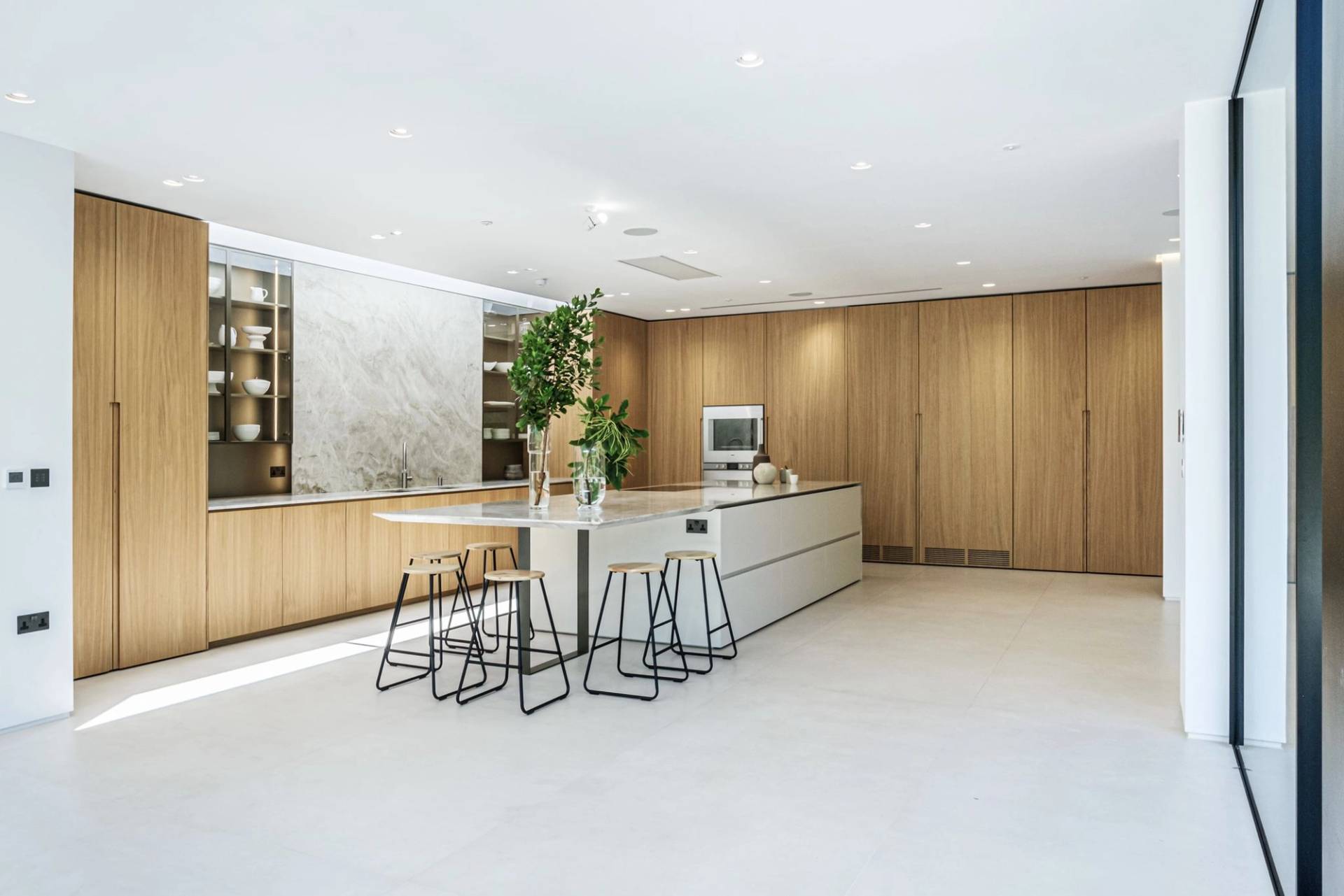 Spacious luxury kitchen and dining room with white marble splashbacks, oak timber cladding, and modern bar stools in Finchley, North London, perfect for food editorial filming, Love Locations N3.