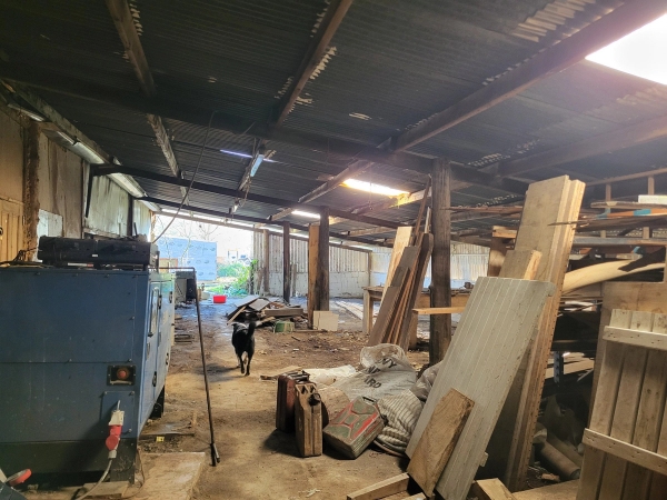 Industrial barn warehouse interior with concrete floor, timber stacks, and high ceilings, Love Locations BN8.