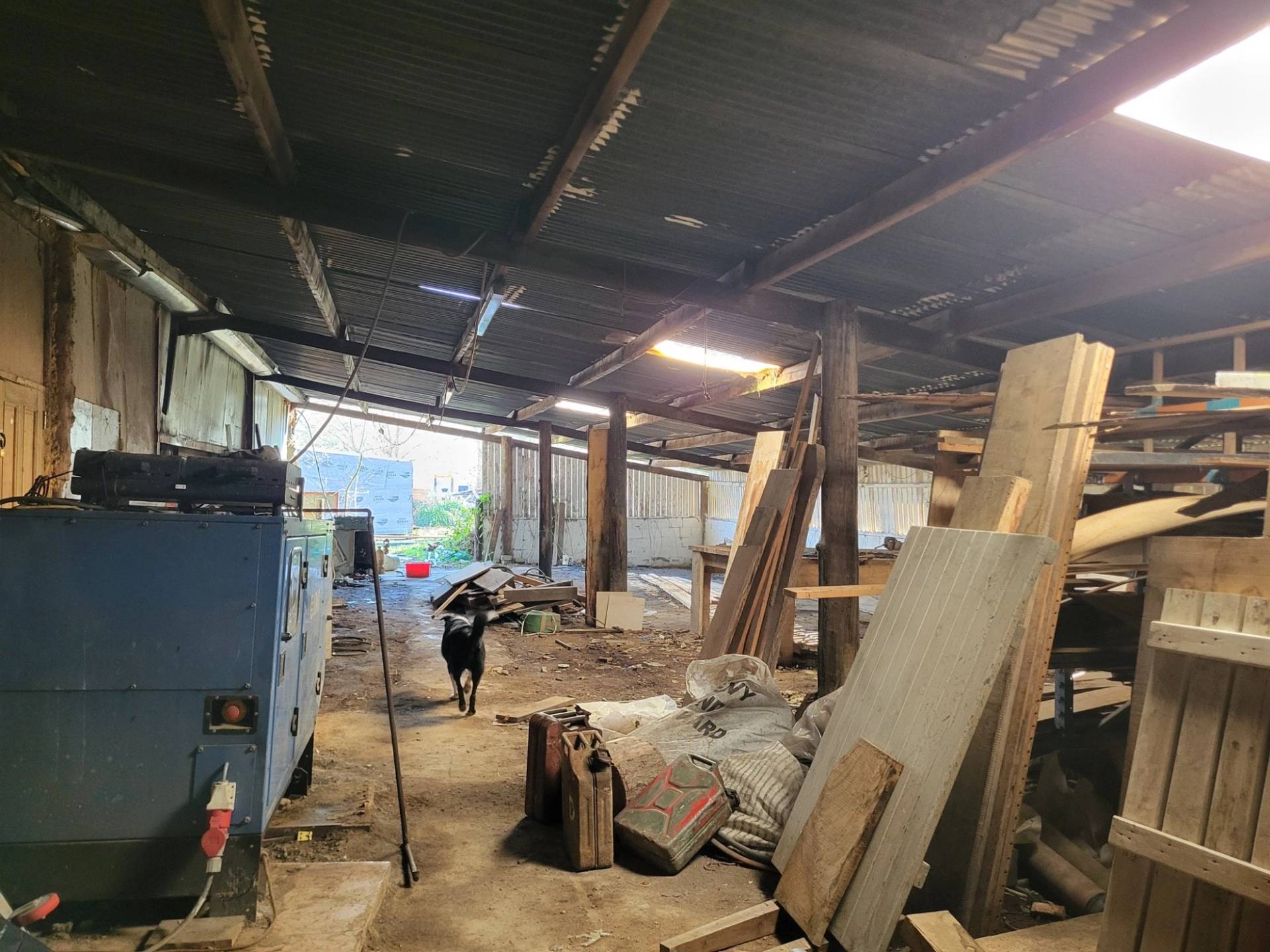 Industrial barn warehouse interior with concrete floor, timber stacks, and high ceilings, Love Locations BN8.