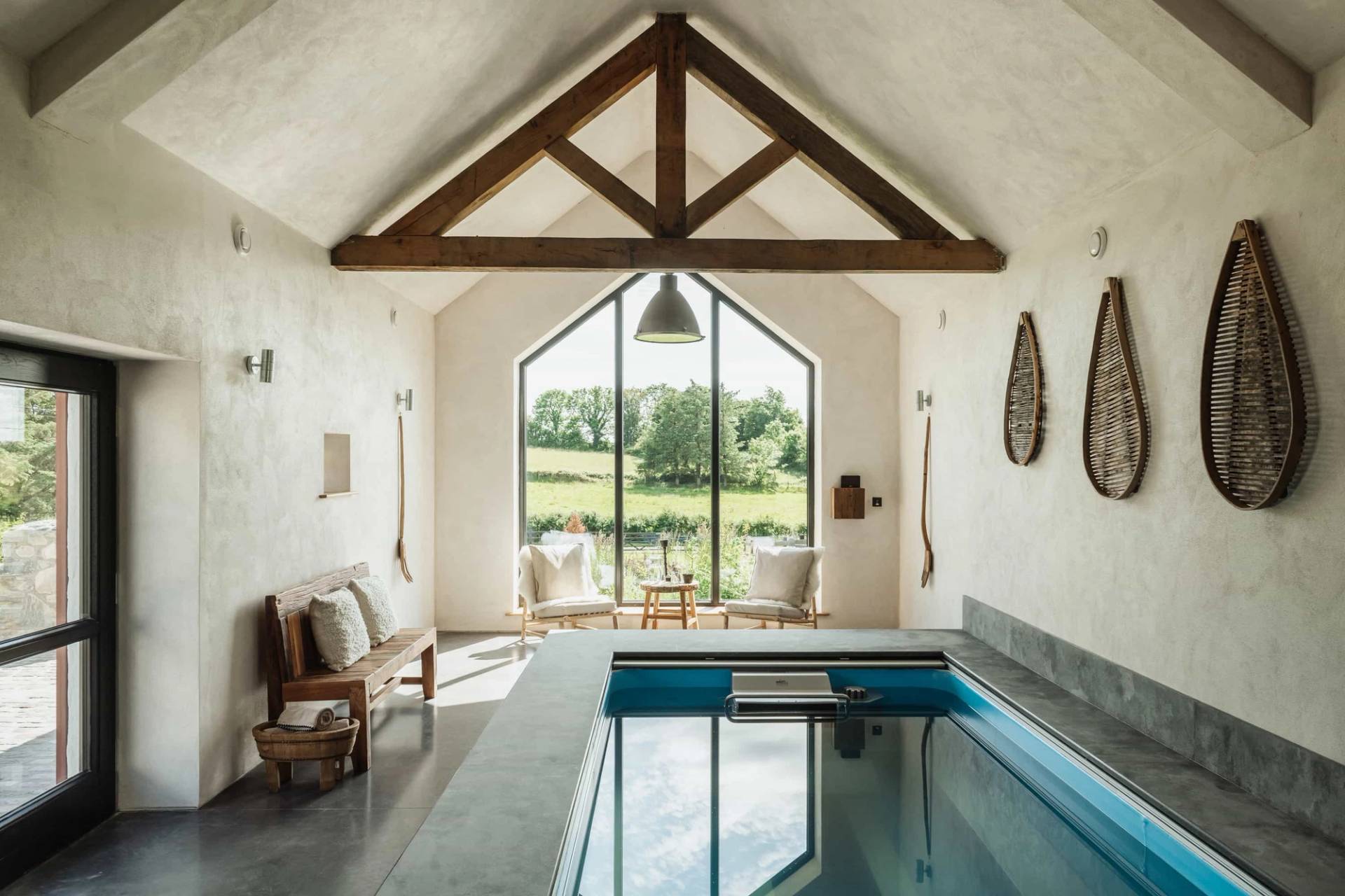 Indoor heated swimming pool film location in Castleblayney County Monaghan Ireland via Love Locations, featuring vaulted timber roof trusses and a large cathedral window.