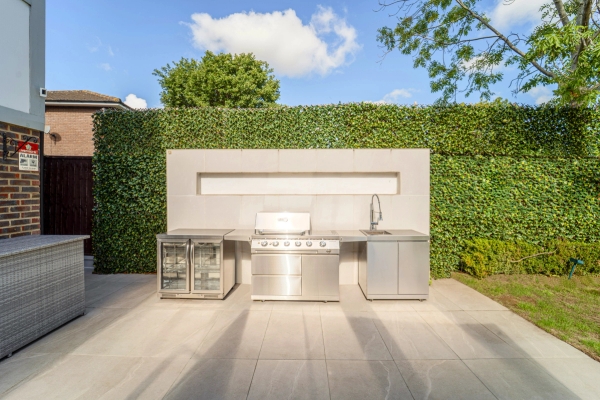 Bespoke stainless steel outdoor kitchen BBQ station built into modern garden walls, Love Locations RM11.