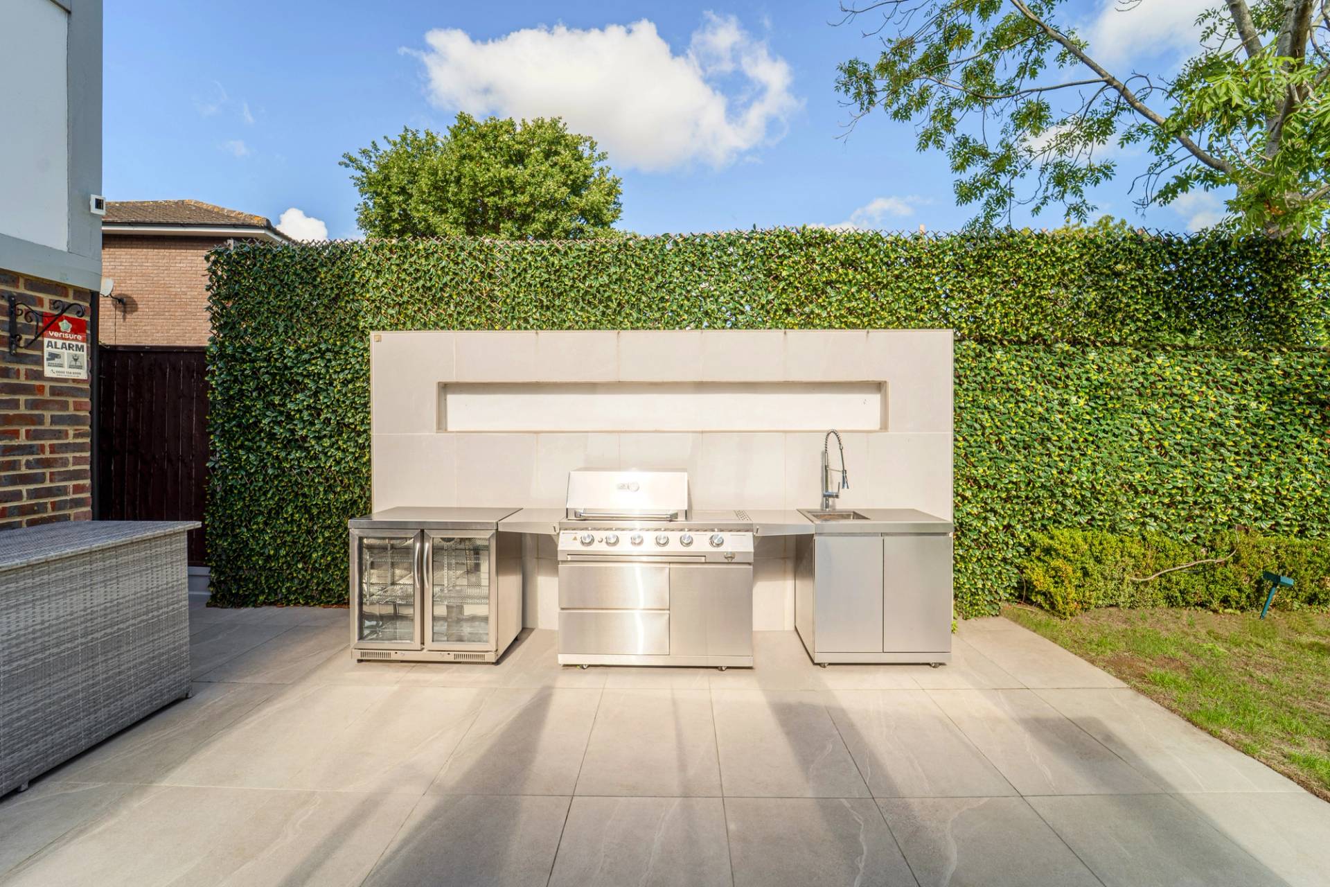 Bespoke stainless steel outdoor kitchen BBQ station built into modern garden walls, Love Locations RM11.
