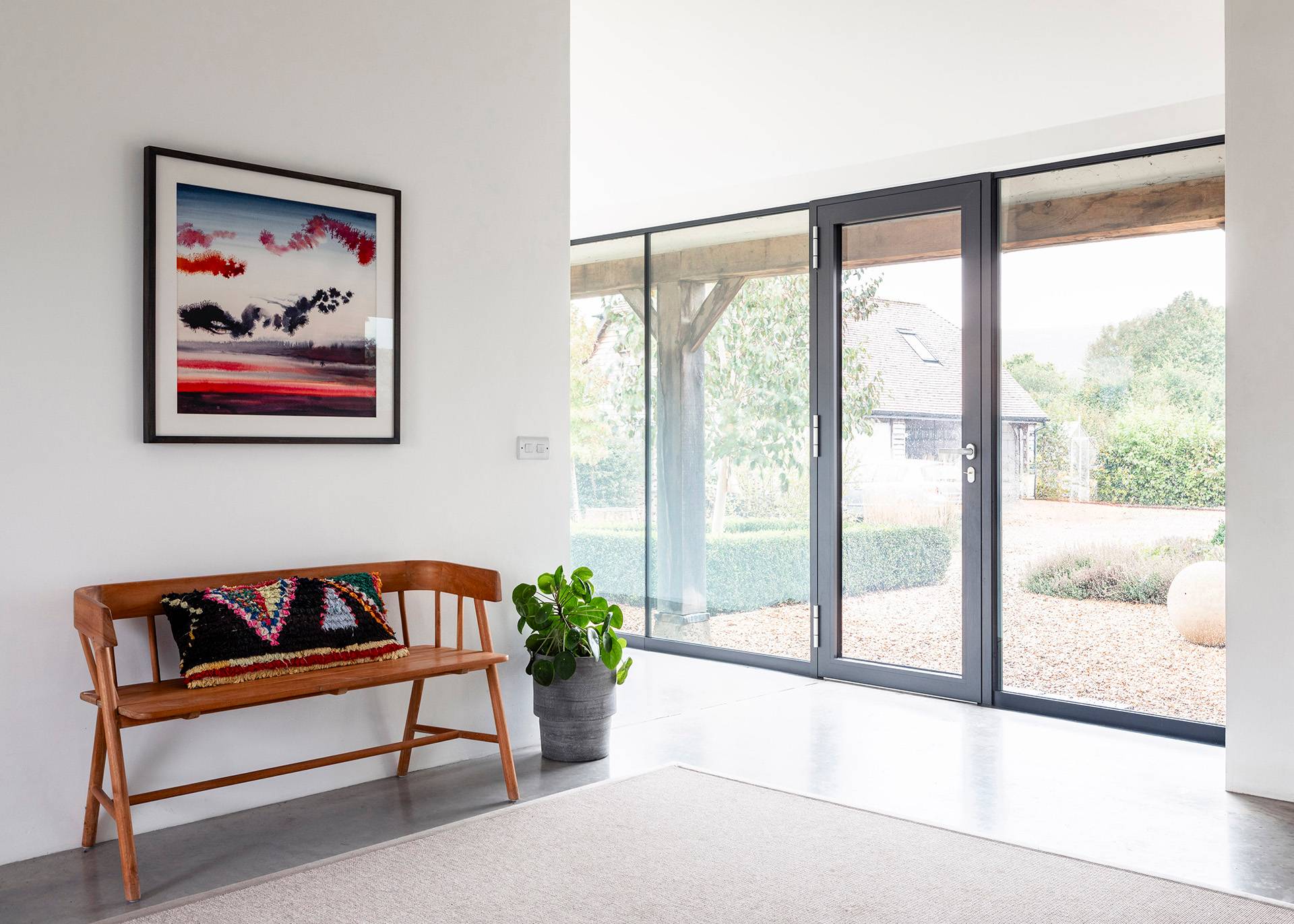 Entrance hallway with full-height sliding glass doors opening onto an outdoor paved courtyard, Love Locations SN8.