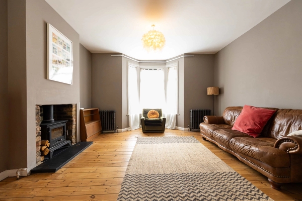 Love Locations cozy sitting room location Forest Gate: Characterful Victorian living area with warm greige walls, stripped floorboards, and a bay window nook, tailored for drama filming and interview sets.