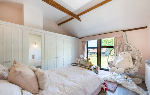 Sunlit residential bedroom location featuring a hanging swing chair and direct garden views in Chelmsford, Love Locations.