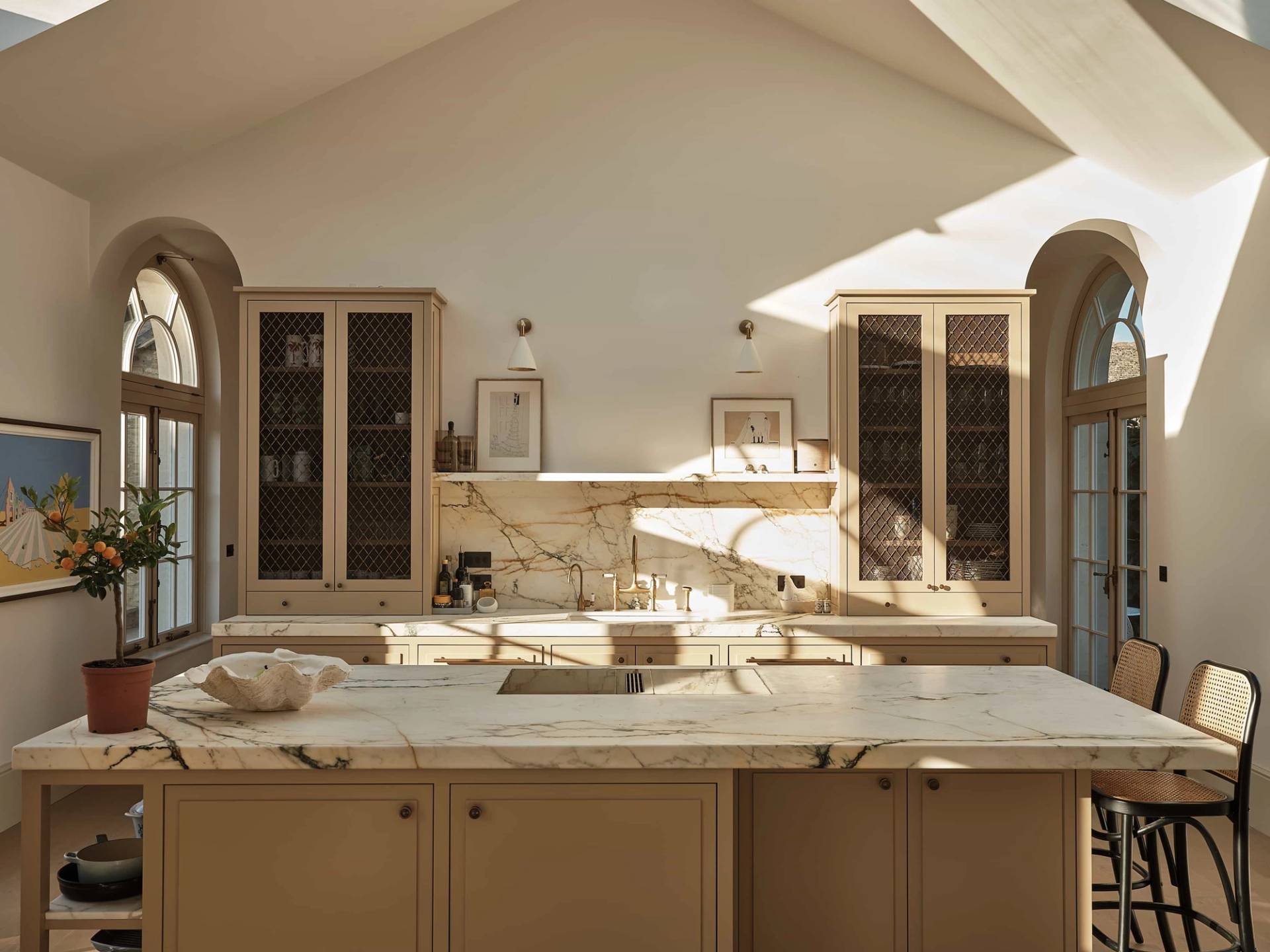 Luxury marble kitchen island with bespoke cabinetry and integrated appliances set under high vaulted ceilings, ideal for culinary commercials, Love Locations OX7.
