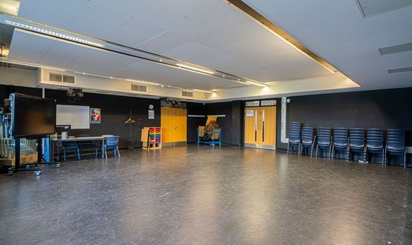 Love Locations production staging space London SE2: Wide multi-purpose drama hall showing double doors and a functional layout, ideal for backstage scenes and commercial media sets.