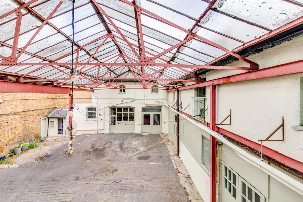 Industrial filming location with period multi-paned windows and steel roofing structure, exclusively on Love Locations.