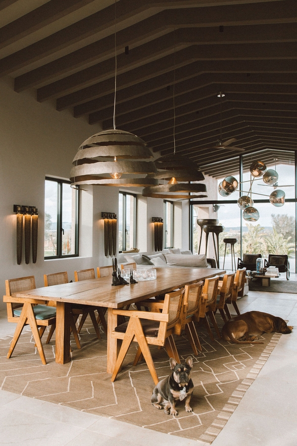 Bespoke dining room set with large metallic pendant lamps, long timber dining table, and natural light, Love Locations 07630.