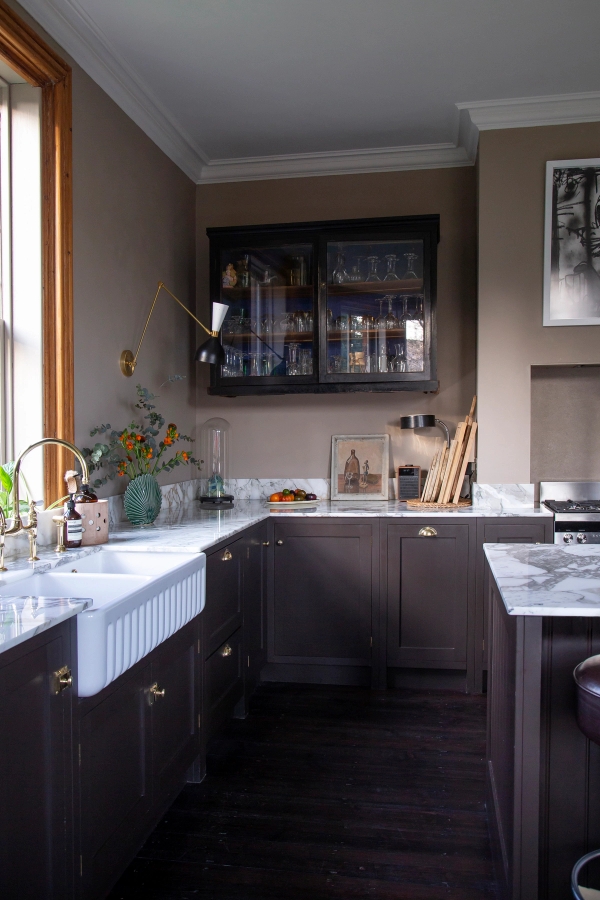 Dark wood kitchen cabinets with ceramic butler sink, brass tap, and marble countertops, Love Locations ME13.