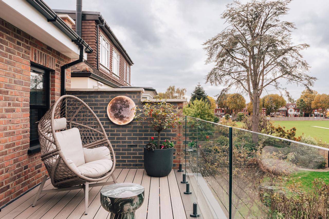 First-floor outdoor balcony terrace with a grey hanging egg chair and glass balustrade, ideal for relaxation lifestyle shoots, Love Locations W5.