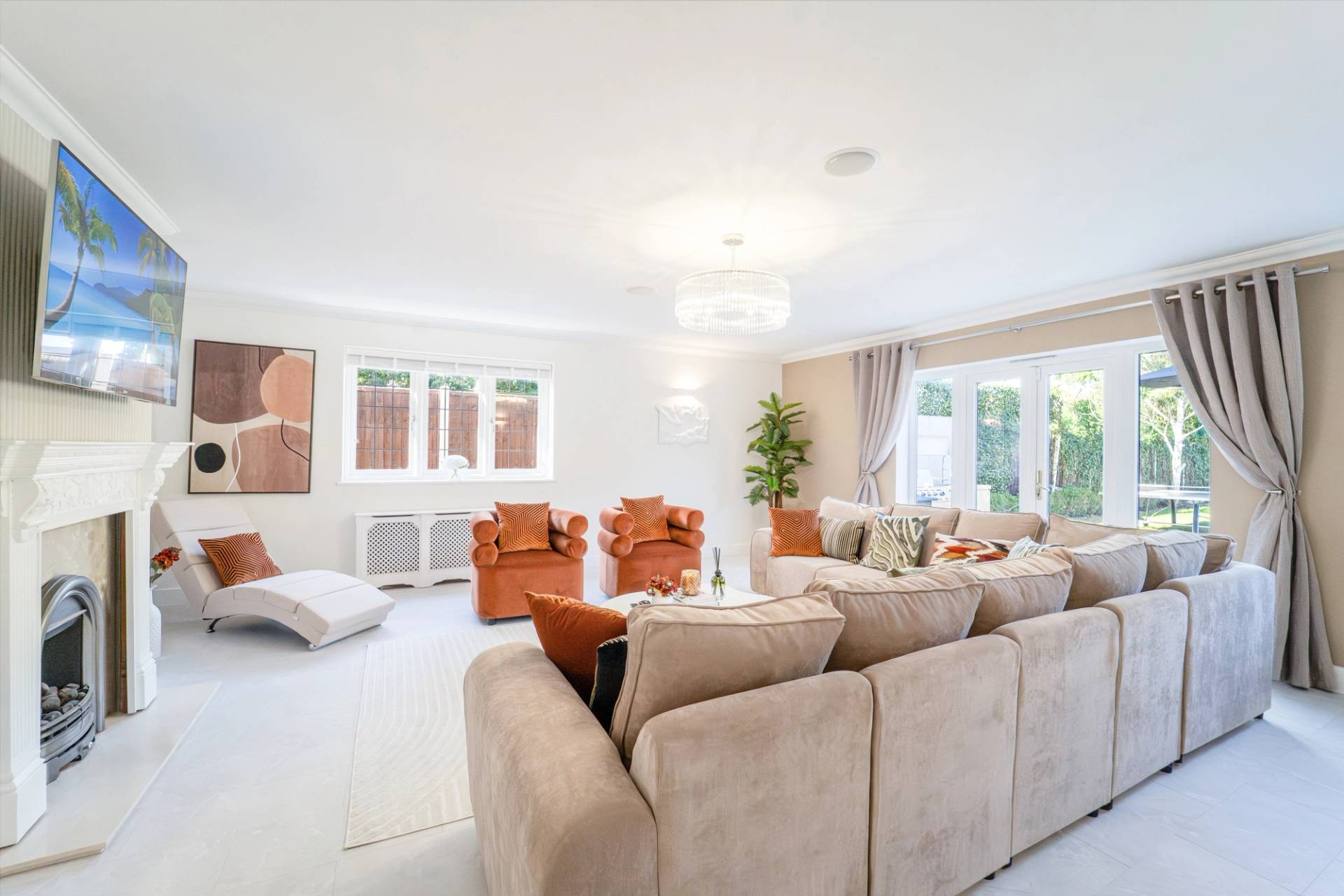 Spacious family lounge featuring tan velvet armchairs, neutral sectional couch, and double windows, Love Locations RM11.