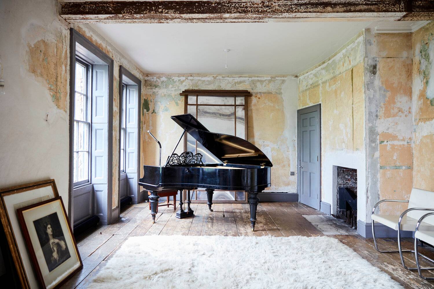 Distressed grand reception room featuring a grand piano, original floorboards, peeling plaster walls, and sash windows, perfect for high-fashion editorial photography, Love Locations.
