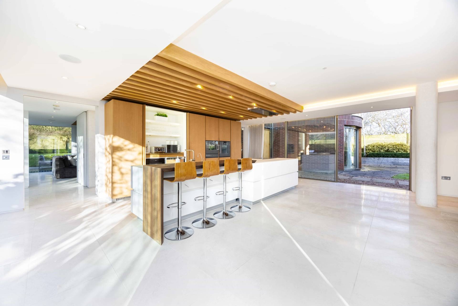 Wide perspective of a open-plan kitchen and dining area with slatted timber ceiling features in Radlett, Love Locations WD7.
