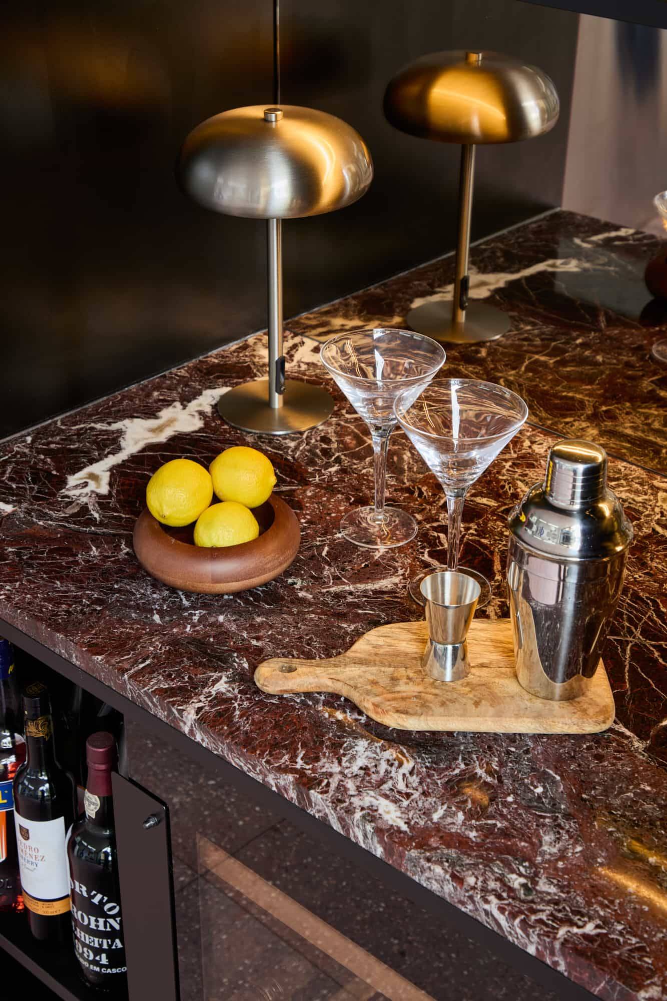 Love Locations luxury lifestyle photography location SE23: Detailed view of a dark marble bar counter styled with cocktail glasses and a shaker, perfect for editorial food and drink features.