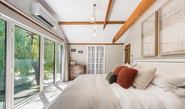 Contemporary bedroom location room featuring sliding glass doors opening out to a private balcony deck, via Love Locations CM3.