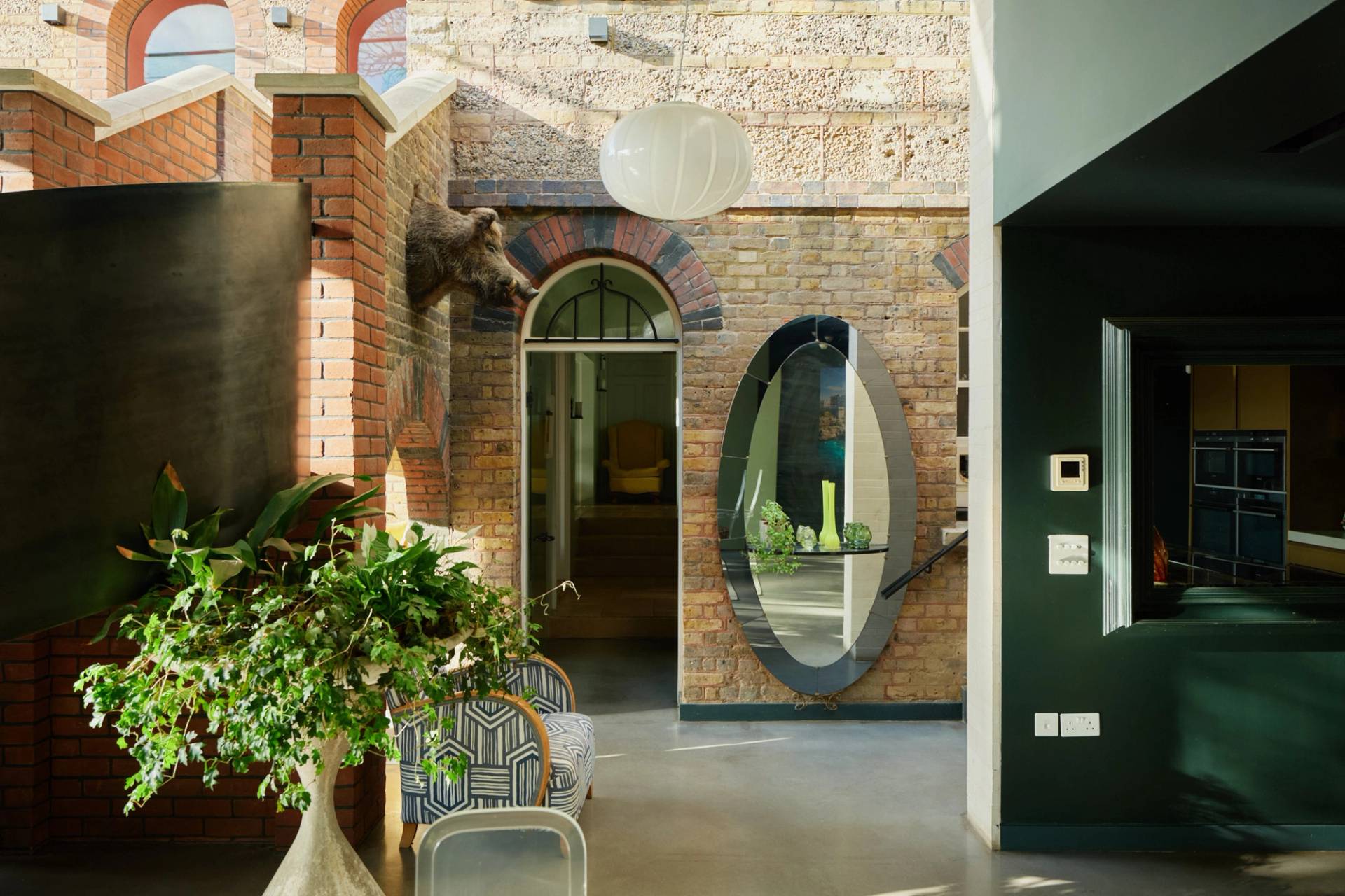 Character entrance hall with exposed brickwork, large oval mirror, and paper globe pendant lighting, ideal for commercial video production, Love Locations SW20.