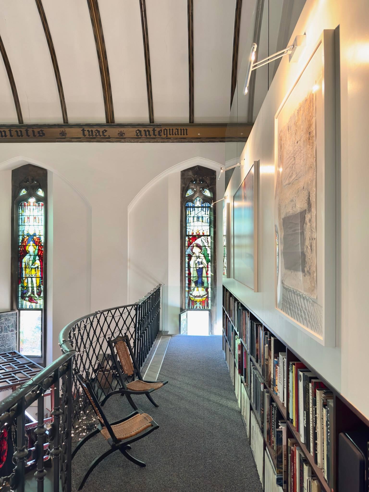 Upper balcony walkway featuring decorative black iron railings and stained glass details in an Oval SE5 location home through Love Locations.