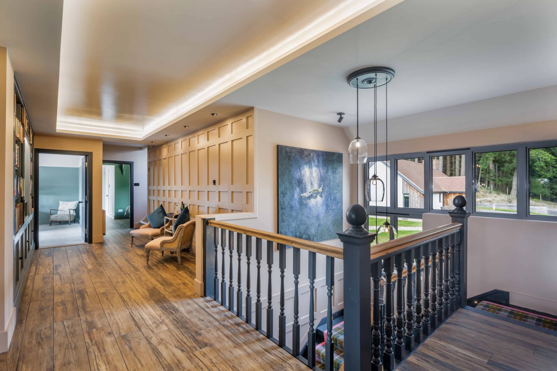 Upper floor gallery landing with dark wood balustrades, oak wall panelling, and soft cove ceiling lighting, ideal for period and modern drama scenes, Love Locations GU27.