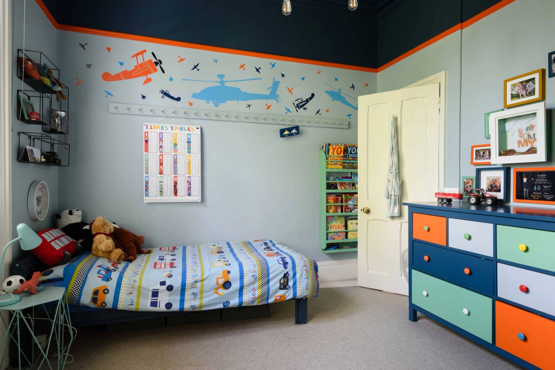 Playful kids bedroom with airplane wall mural, blue trim, and wooden bed frame, Love Locations TW11.