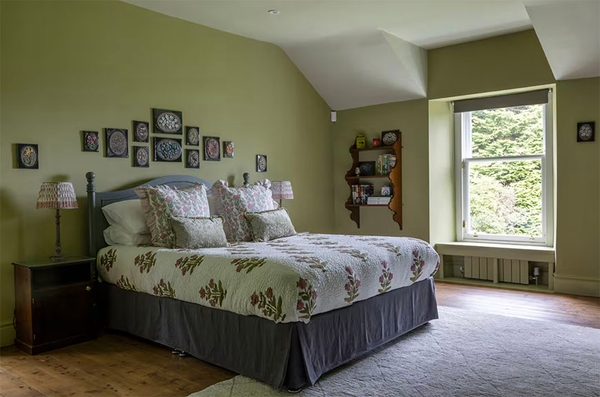 Glenstriven guest bedroom with decorative painted wardrobe panels and soft natural light.