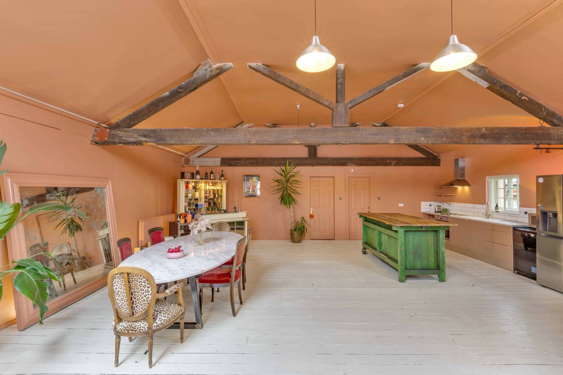 Creative kitchen studio set featuring a rustic green wooden island unit and exposed rafters, managed by Love Locations.