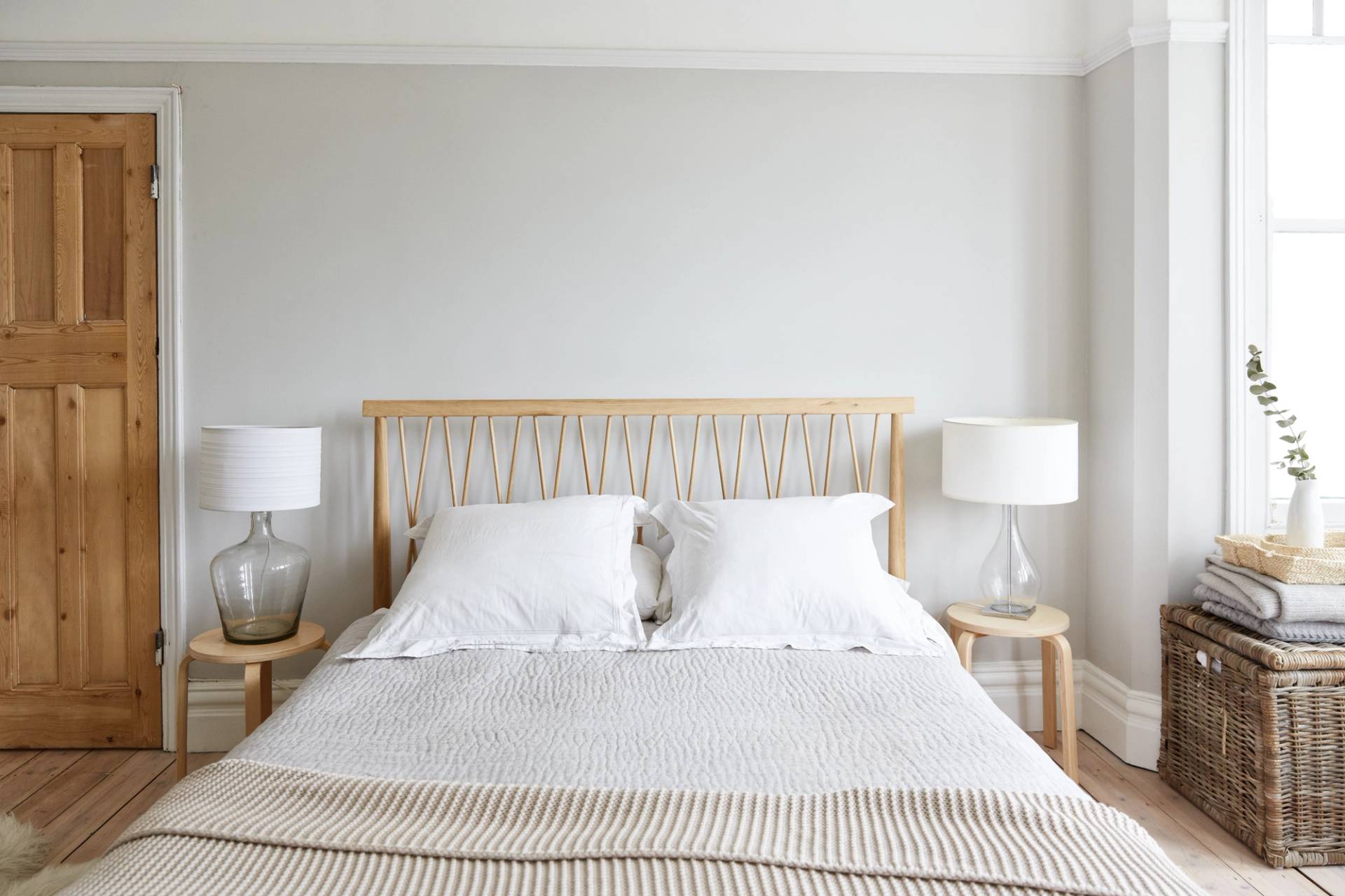 Serene period bedroom in Southgate, N13 with a woven light wood bed frame, white linen bedding, and neutral grey walls, Love Locations.