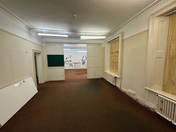 Spacious distressed institutional hall inside a derelict building for hire, ideal as a raw film set backdrop via Love Locations NG9.