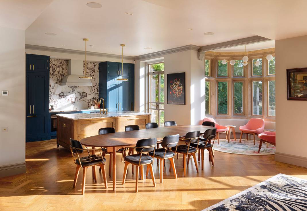 Luxury Cotswold manor kitchen and dining room shoot location in Oxfordshire, OX7 featuring parquet wood floors, long dining table, and stone bay windows via Love Locations.