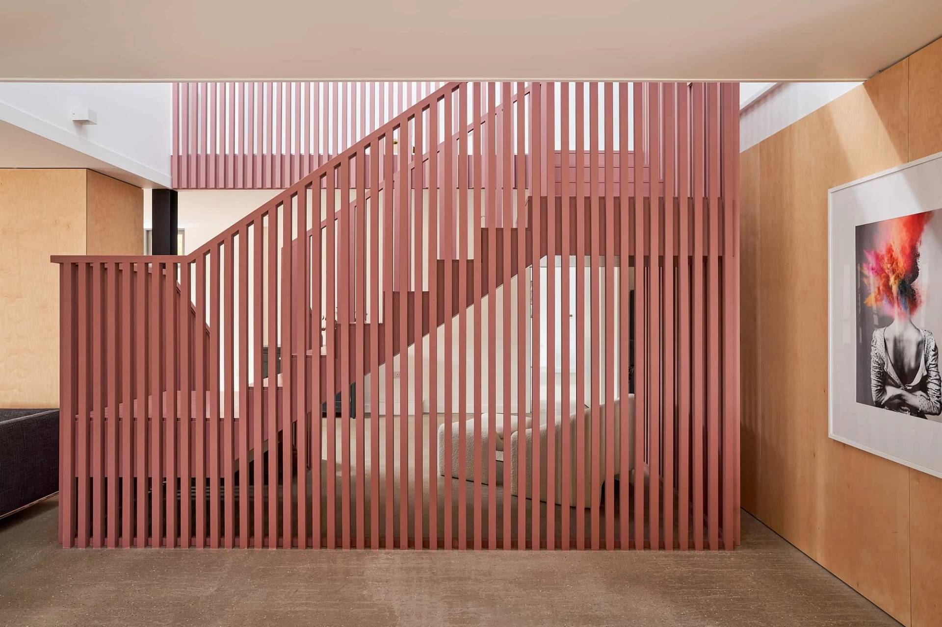 Close-up view of a terracotta pink slatted wooden staircase structure in a modern agricultural barn conversion, Love Locations IP30.