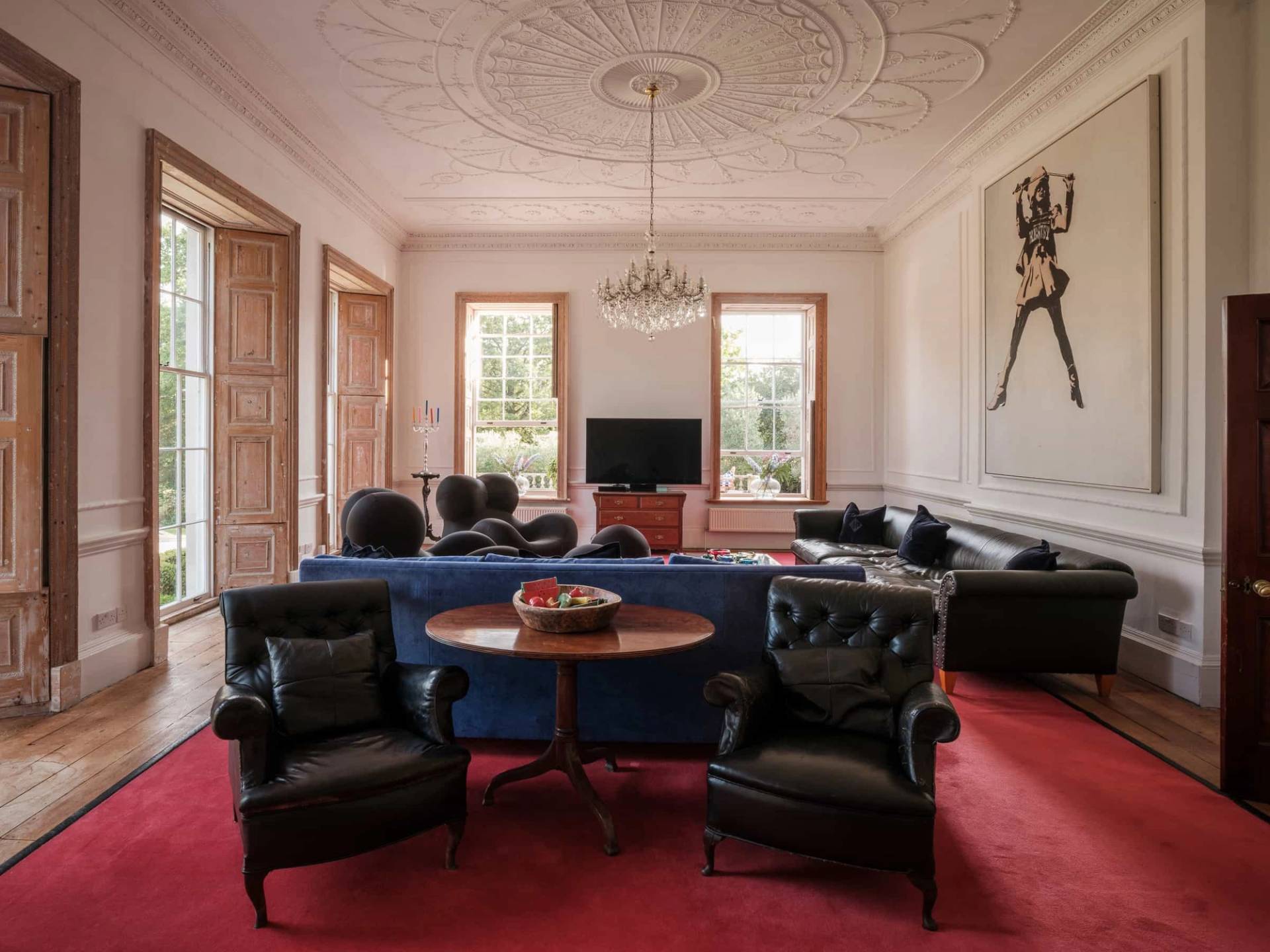 Georgian reception room view showing a central coffee table, black sofas, and grand ceiling plasterwork, Love Locations RG42.