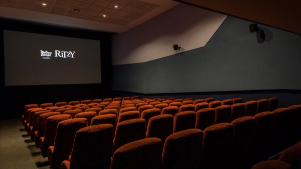 Angled view from the upper auditorium looking across plush red velvet seating toward the screen at The Ritzy Screen 4 film location in Brixton SW2, available through Love Locations.