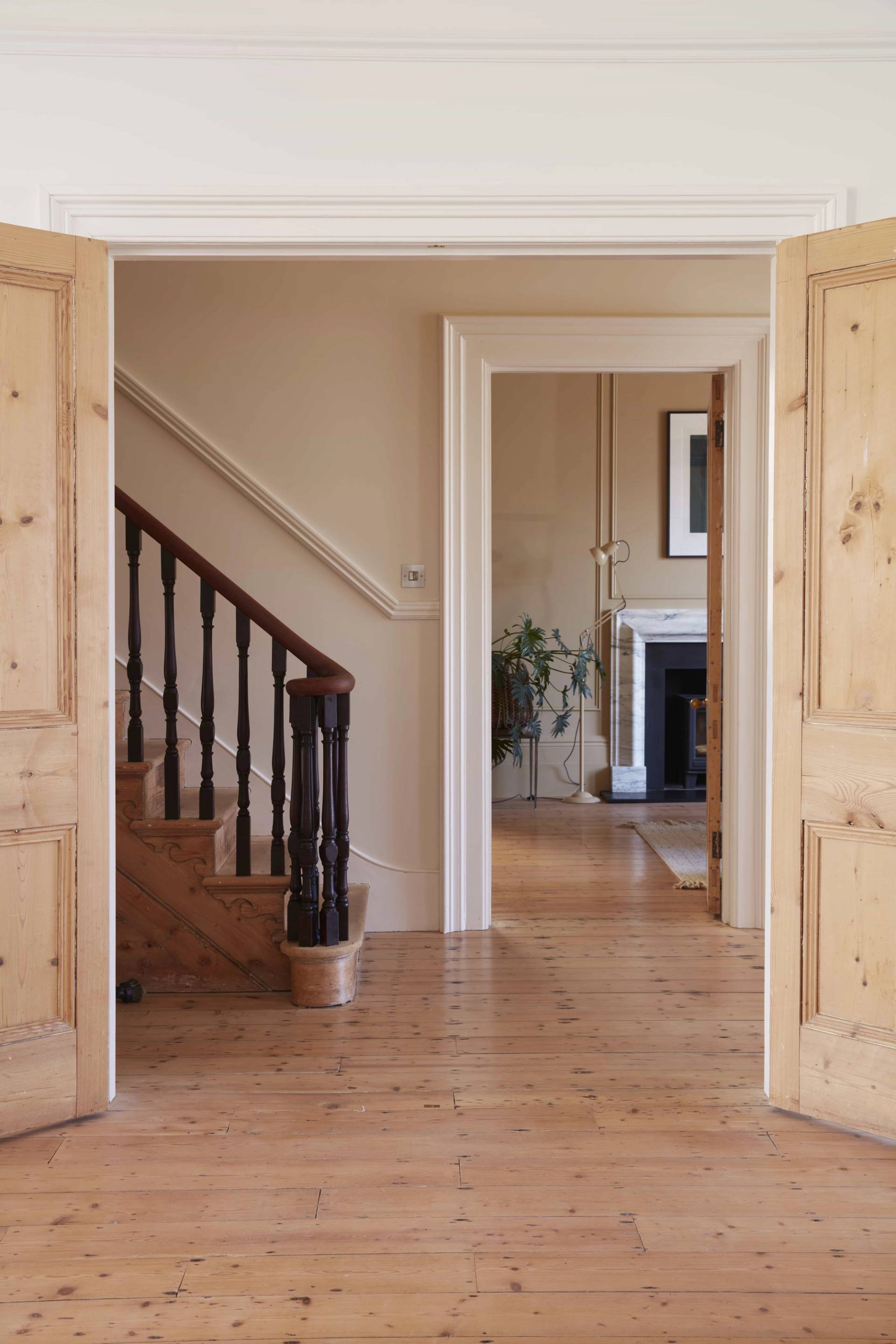 Stately entrance hallway showing traditional dark wood banisters and stripped pine floorboards, Love Locations.