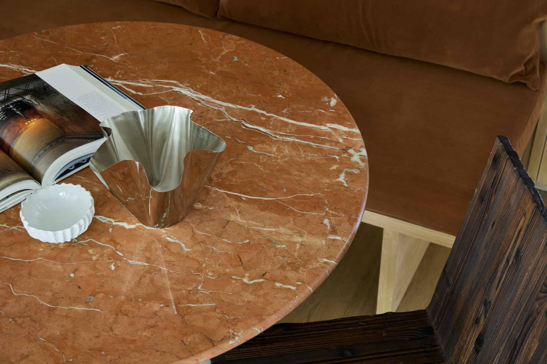 Love Locations luxury materials shoot location SE23: Close-up of an organic peach marble dining table surface styled with a designer steel bowl, perfect for product photography.