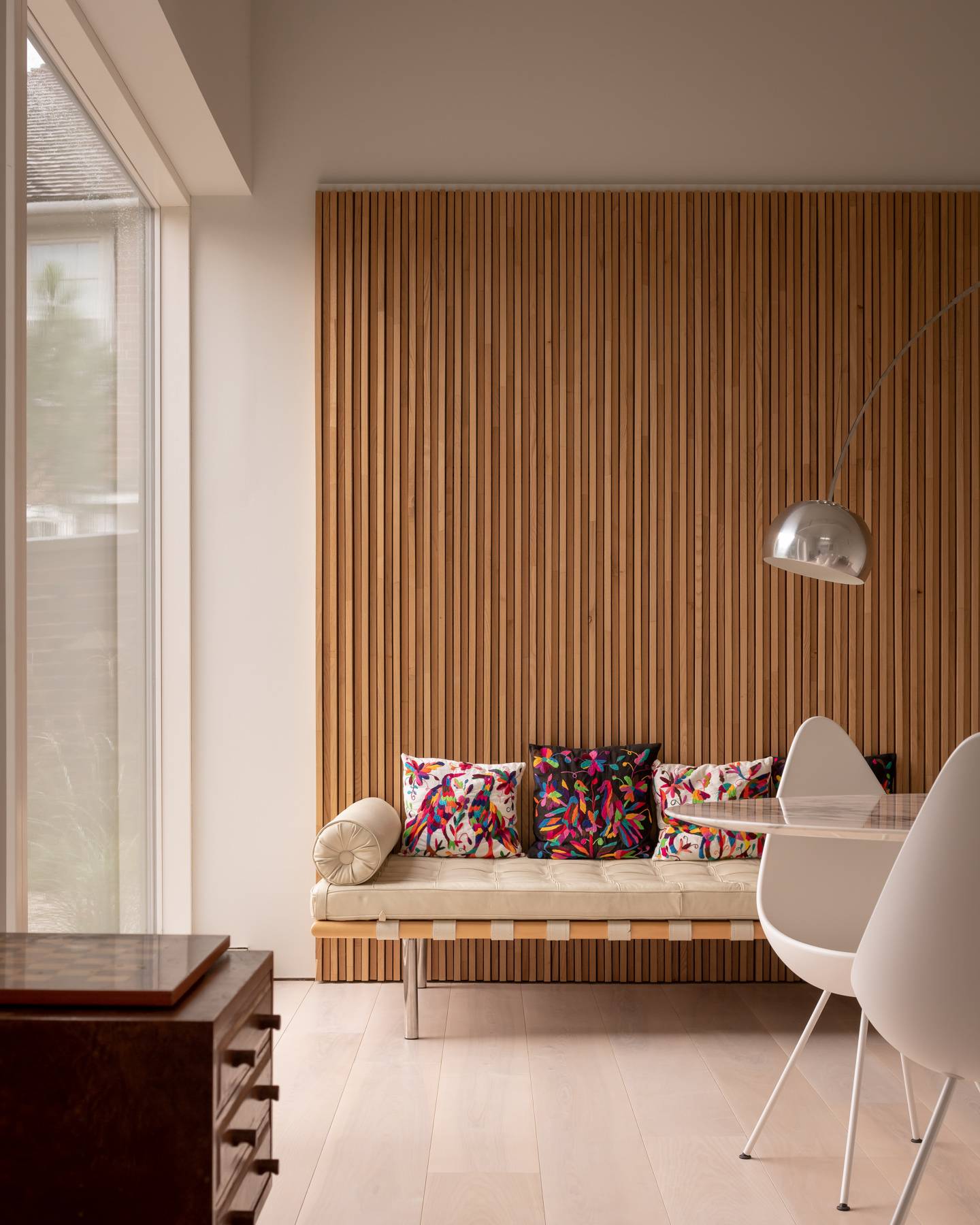 Cozy seating alcove featuring a low daybed set against bespoke vertical oak slat panelling, Love Locations BN3.