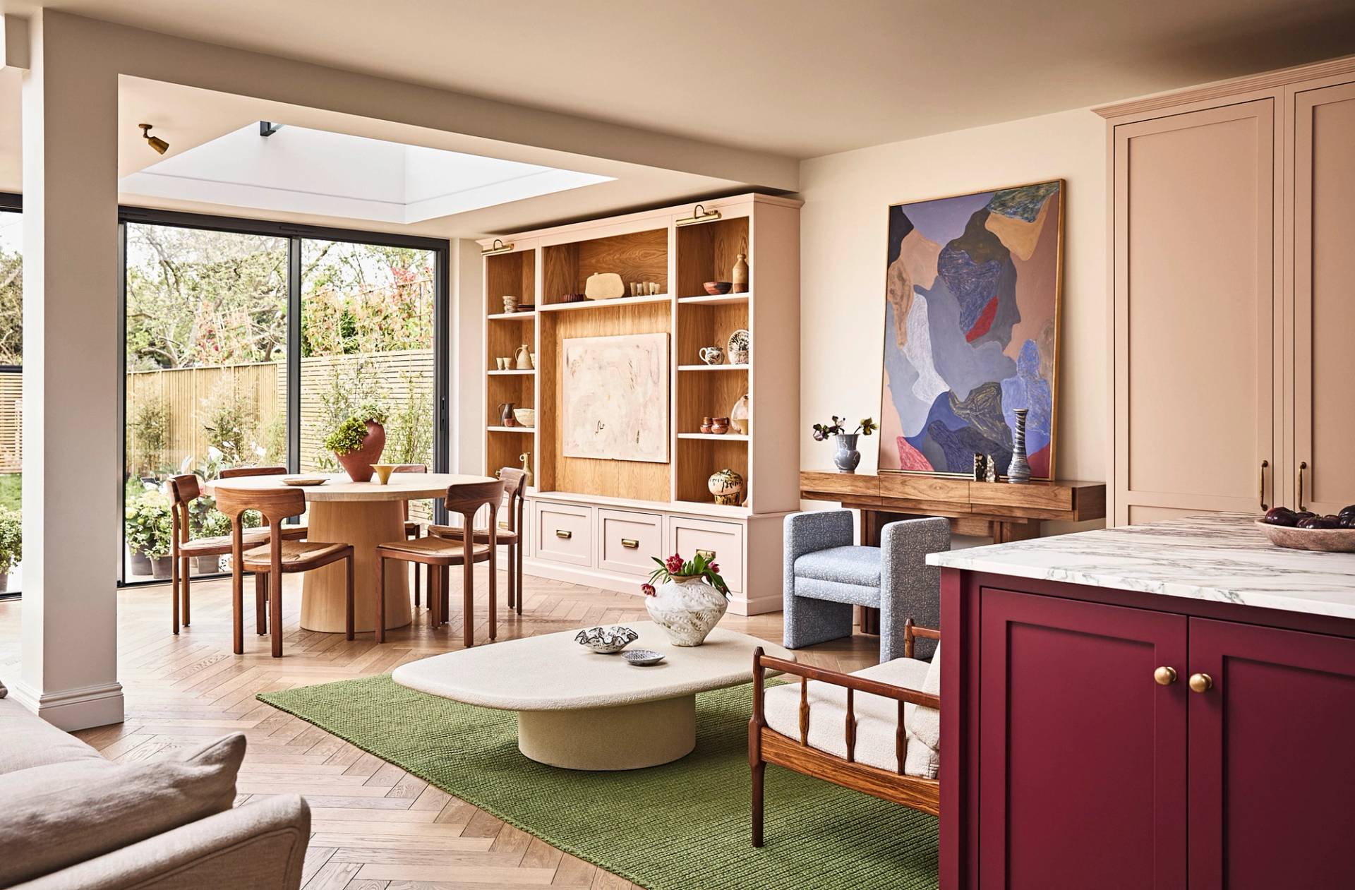 Open-plan living space transition showing an oak dining alcove, green rug, and coffee table layout, Love Locations SE21.
