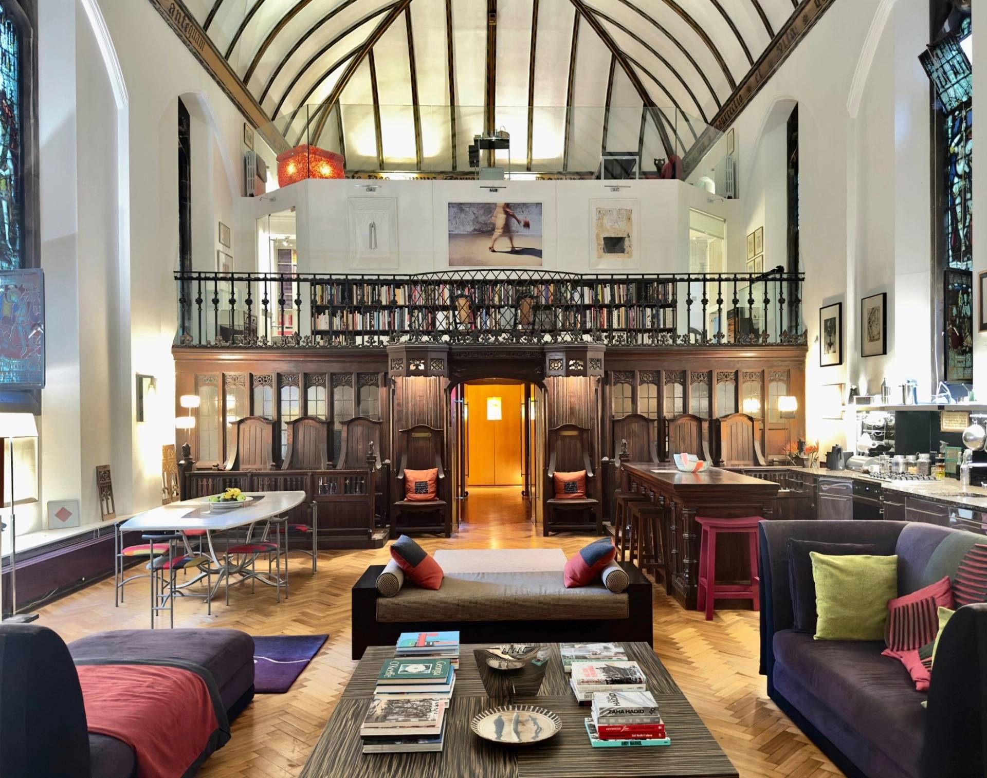 Looking towards the wood-panelled dining gallery and mezzanine inside a church conversion film venue in Oval SE5 by Love Locations.