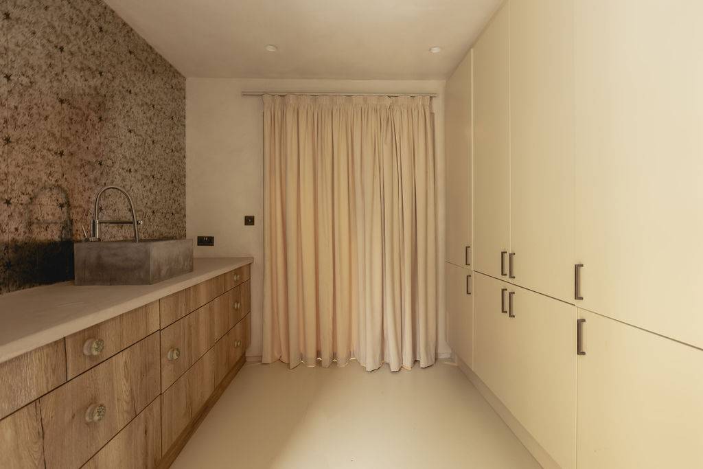 Guest bedroom featuring fitted wooden storage wardrobes and neutral linen window curtains, Love Locations GU32.