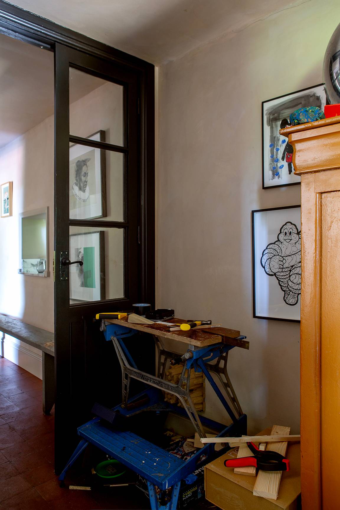 Corridor nook with dark wood glass partition screen and small wooden workbench table, Love Locations ME13.