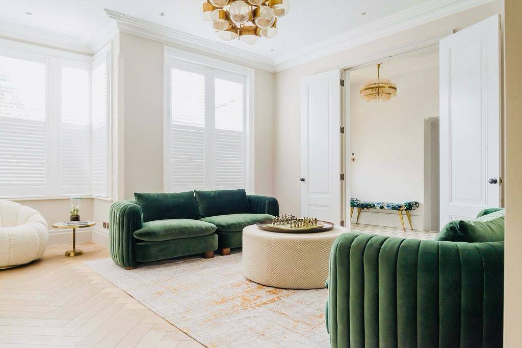Elegantly styled living room featuring green velvet armchairs and a round ottoman coffee table, Love Locations TW11.