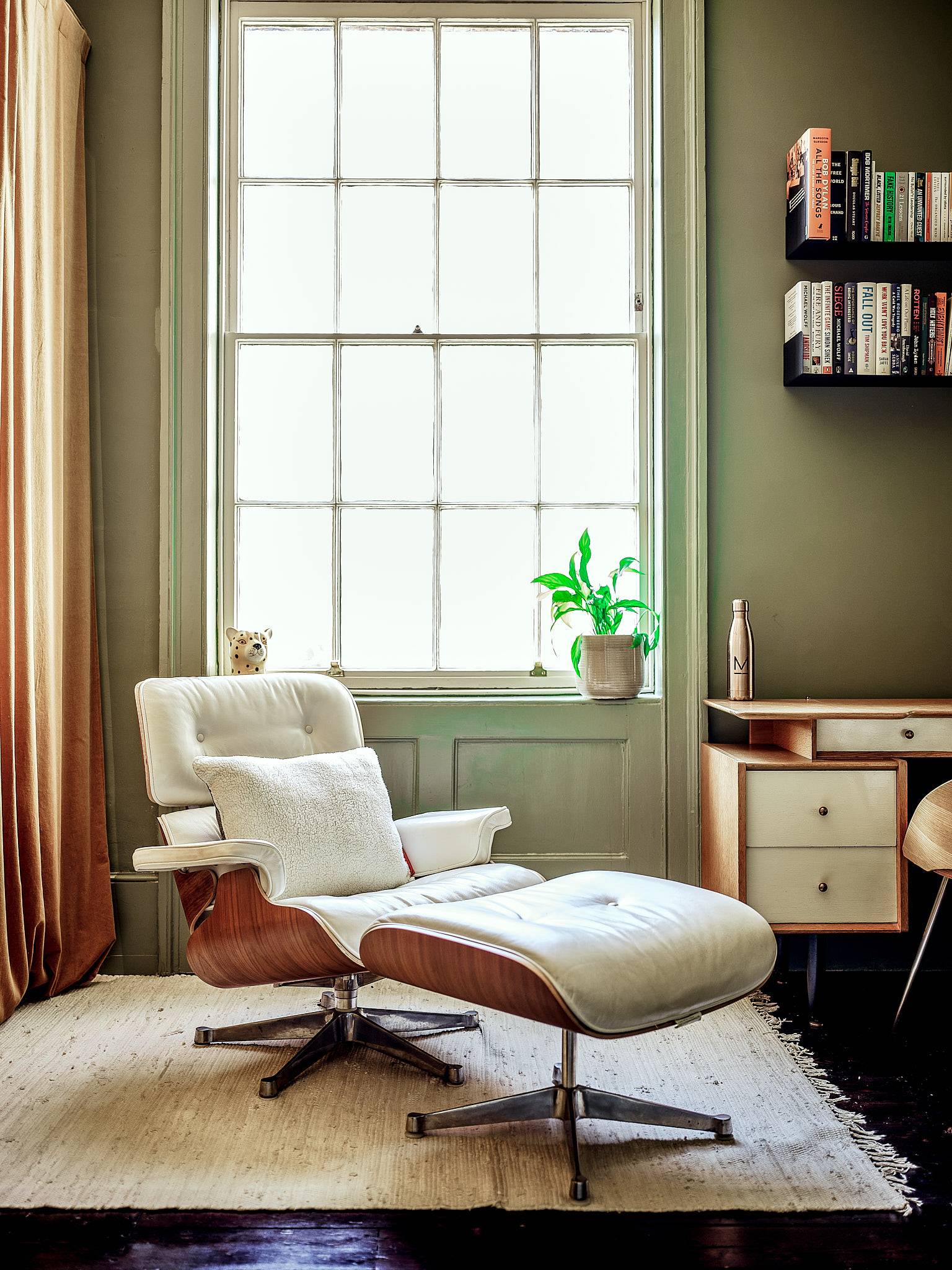 Mid-century modern study corner featuring an Eames lounge chair and ottoman set against olive green walls and sash windows, ideal for tech and lifestyle ads, Love Locations ME13.
