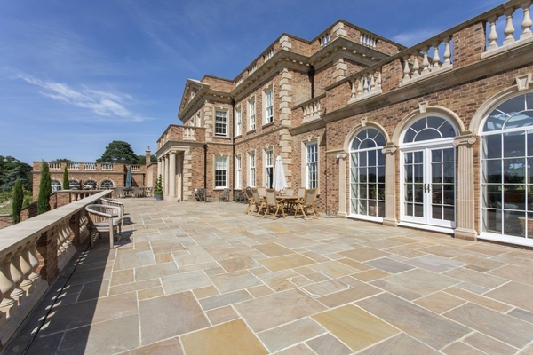 Spacious stone-paved sun terrace outside the main manor house, ideal for outdoor corporate receptions, curated by Love Locations.