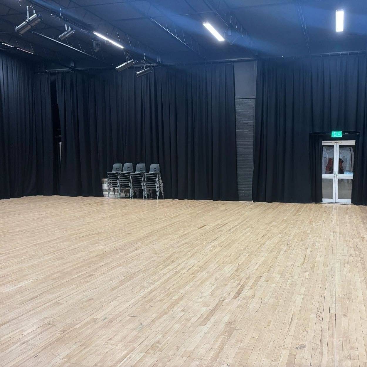 Rehearsal room and drama space in a Sittingbourne grammar school featuring black acoustic drapes and track lighting from Love Locations.