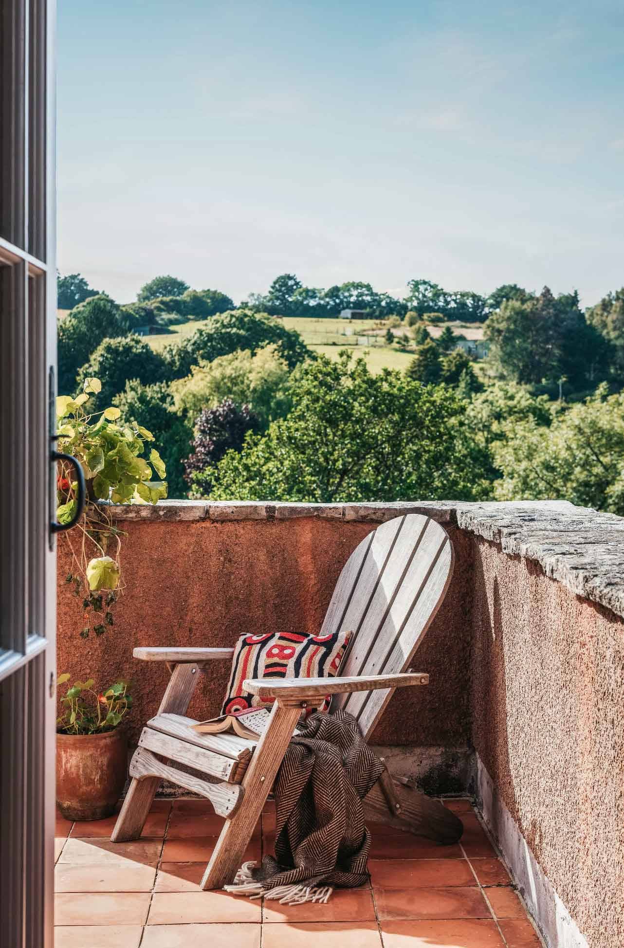 Country house balcony area featuring an Adirondack lounge chair overlooking green valley vistas in Totnes Devon TQ12 from Love Locations.