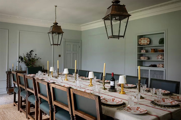 Glenstriven dining room with long table set for a meal and large lantern style ceiling lights
